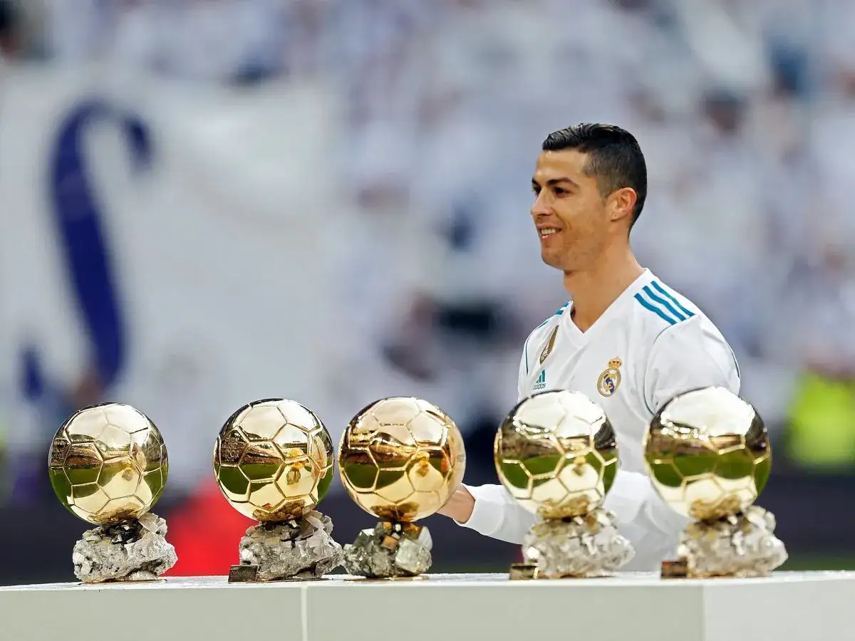 Cristiano Ronaldo z dumą prezentuje swoje pięć złotych piłek, symbolizujących jego niezwykłe osiągnięcia.