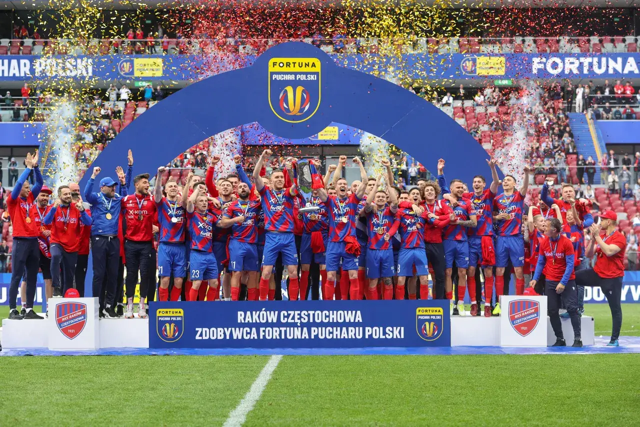 Piłkarze z Częstochowy świętują zdobycie Pucharu Polski, unosząc trofeum wśród konfetti.