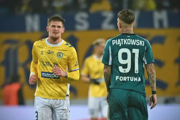Piłkarze na boisku podczas meczu na Arena Lublin dzisiaj. Jeden w żółtej koszulce, drugi w zielonej z numerem 91.