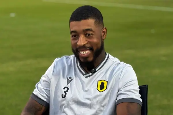 Uśmiechnięty piłkarz Kimpembe w jasnej koszulce z numerem 3 i herbem drużyny.